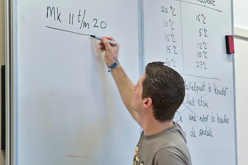 Docent schrijft op white-board