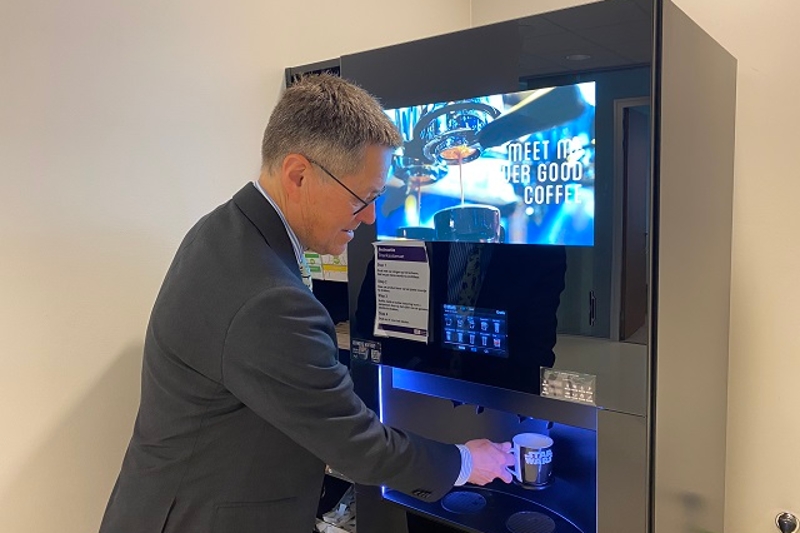 Rik bij de koffiemachine